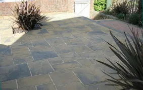 a patio with a brick walkway and a planter